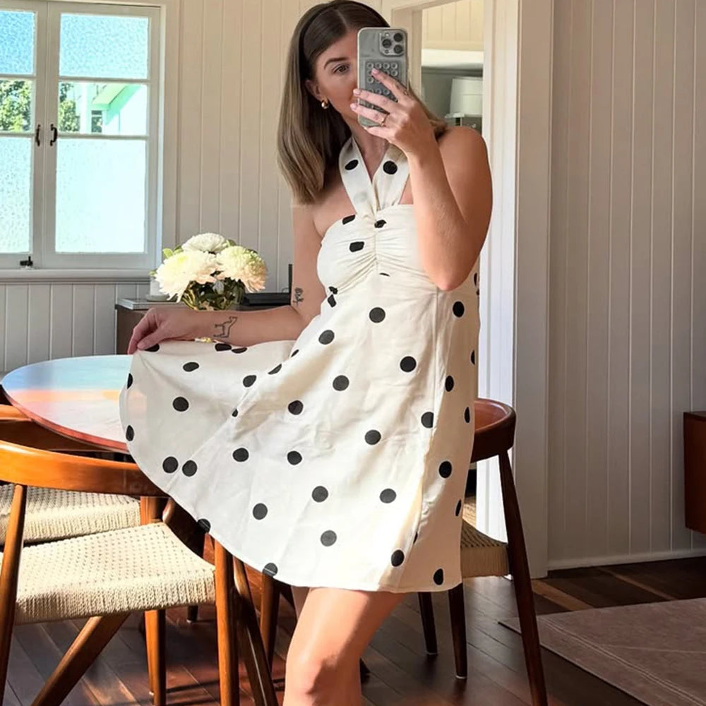 White halter mini dress with black polka dots styled indoors