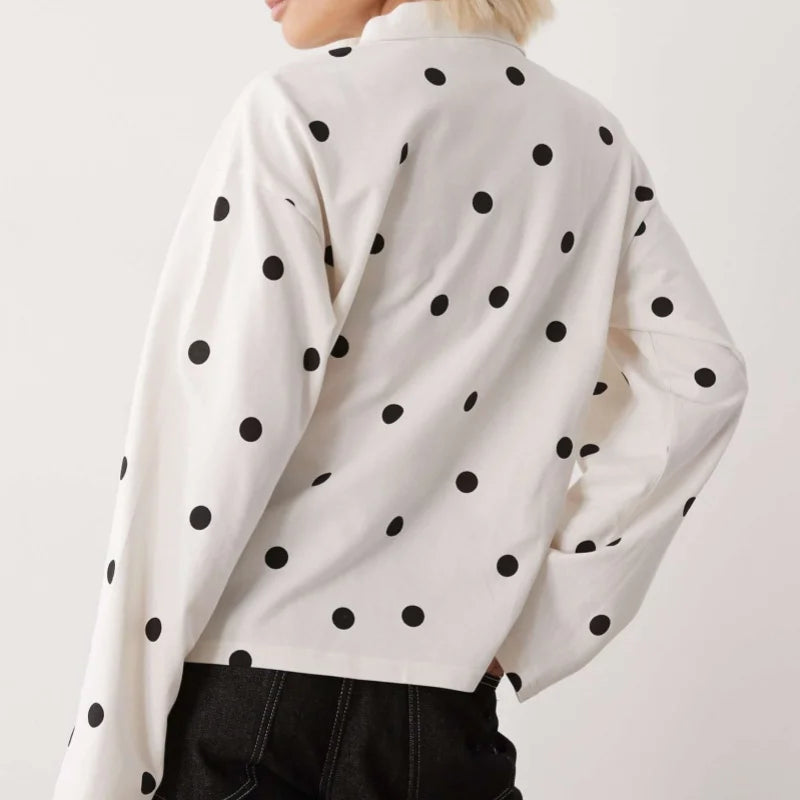 Detail view of the long sleeve and cuff showing fabric drape and playful dot placement.