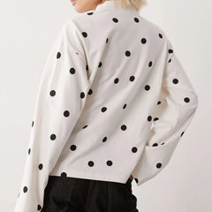 Detail view of the long sleeve and cuff showing fabric drape and playful dot placement.