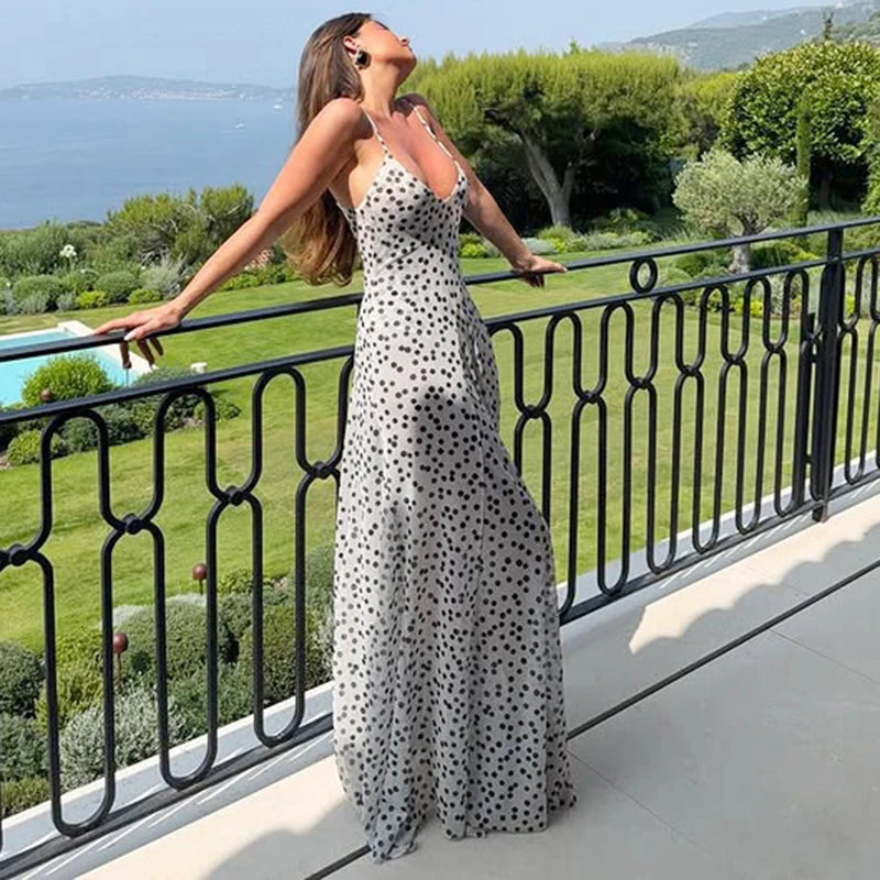 Woman in polka dot mesh V-neck maxi dress styled for scenic balcony parties of greenery and water.