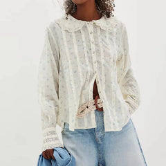 Model wearing a white printed Peter Pan collar blouse styled with denim, photographed against a clean studio background.