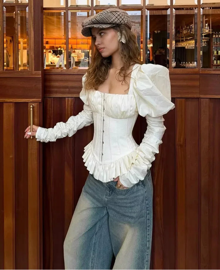 Three-quarter angle highlighting the dramatic puff sleeve shape and square neckline of the ivory blouse, creating a sculpted, editorial silhouette.