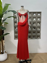 Styled full-length look with gloves and a small textured handbag, showing the clean strapless cut and refined evening shape.