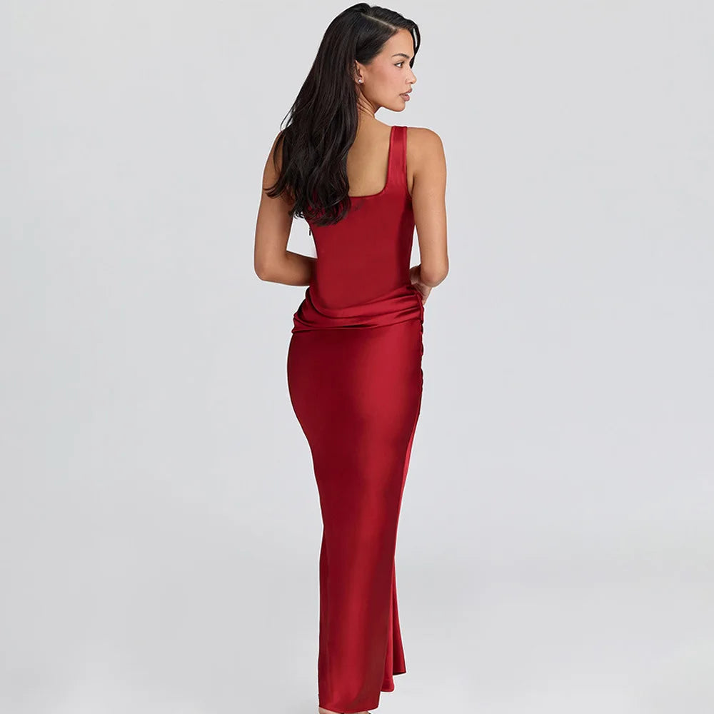 Back angle highlighting the backless cut and sleek straps, with the dress skimming the body in a streamlined evening silhouette.