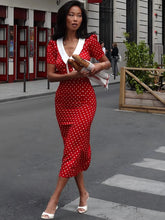 Woman wearing red polka dot V-neck midi dress crossing a street