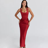 Full-length studio shot of a red satin tank maxi dress with corset-style bodice seams, styled cleanly against a soft gray backdrop.