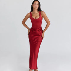 Full-length studio shot of a red satin tank maxi dress with corset-style bodice seams, styled cleanly against a soft gray backdrop.
