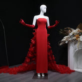 Red strapless evening gown with dramatic floral overskirt on mannequin