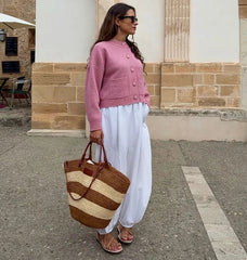 Angled view of the pink button-front cardigan showing roomy sleeves and easy drape, styled for a polished everyday layering look.