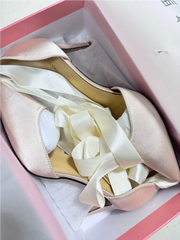 A close-up of the ribbon-bow detail on the shoe.