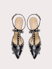 A close-up of the rivet and butterfly detail on the sandal.