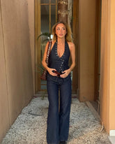 Close view of button accents and rivet-style detail on a halter vest top