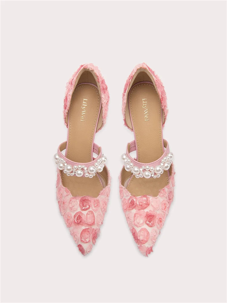 Pink floral shoes with pearl embellishments on a light gray background