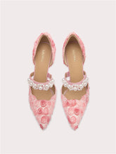 Pink floral shoes with pearl embellishments on a light gray background