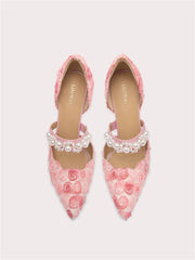 Pink floral shoes with pearl embellishments on a light gray background