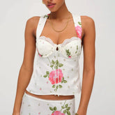 Woman wearing a white floral bustier top with rose print and square neckline on a white background