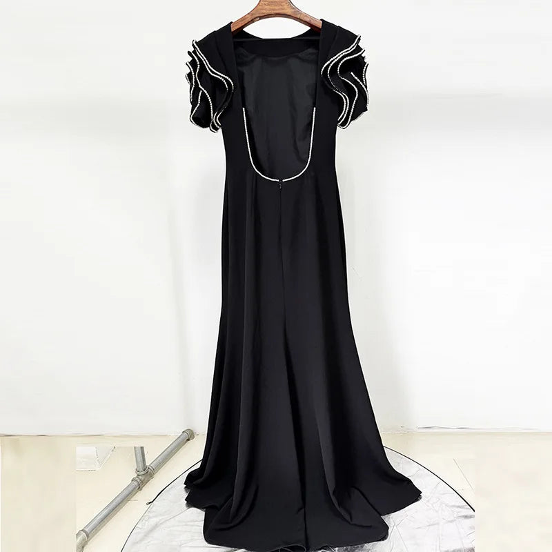 Full-length view of the black A-line maxi dress showing its floor-grazing silhouette and balanced proportions.