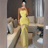 Mirror-selfie editorial of a ruched neck-mounted maxi dress with mesh frill hem styled in a modern living room.