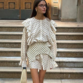 Front view of floral ruffled mini dress with waist seal and buttoned top