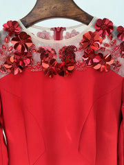 Runway celebrity evening gown in red with floral embellished sleeves on a hanger against a light blue background