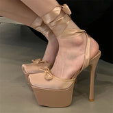 Beige high-heeled shoes with ribbon details on a neutral background