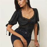 Woman wearing a satin puff sleeve blouse with lace neckline