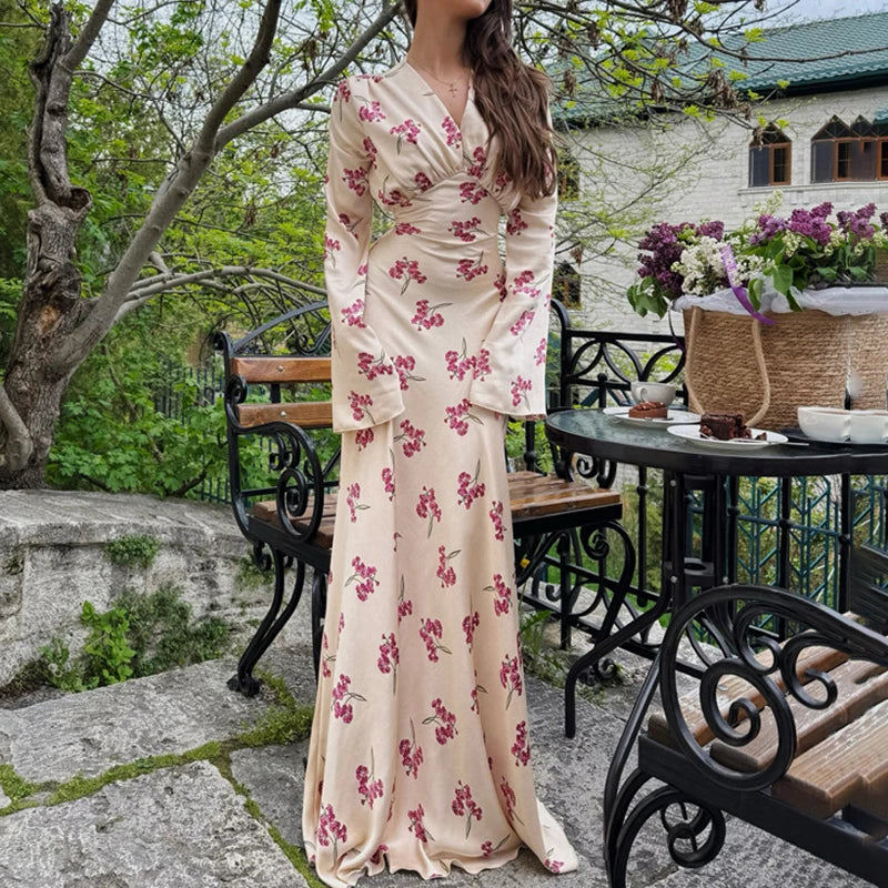 A woman wearing an elegant V-neck satin A-line dress with long sleeves.