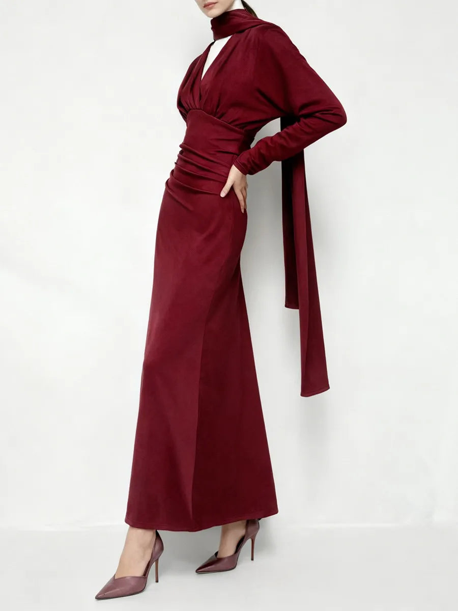 Close-up of the ribbon waist detail on a maroon satin gown.