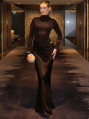 Woman in a floor-length sculpted gown, perfect for winter events, standing in an elegant interior setting