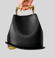 Close-up of metal top handle and sculptural bucket bag opening