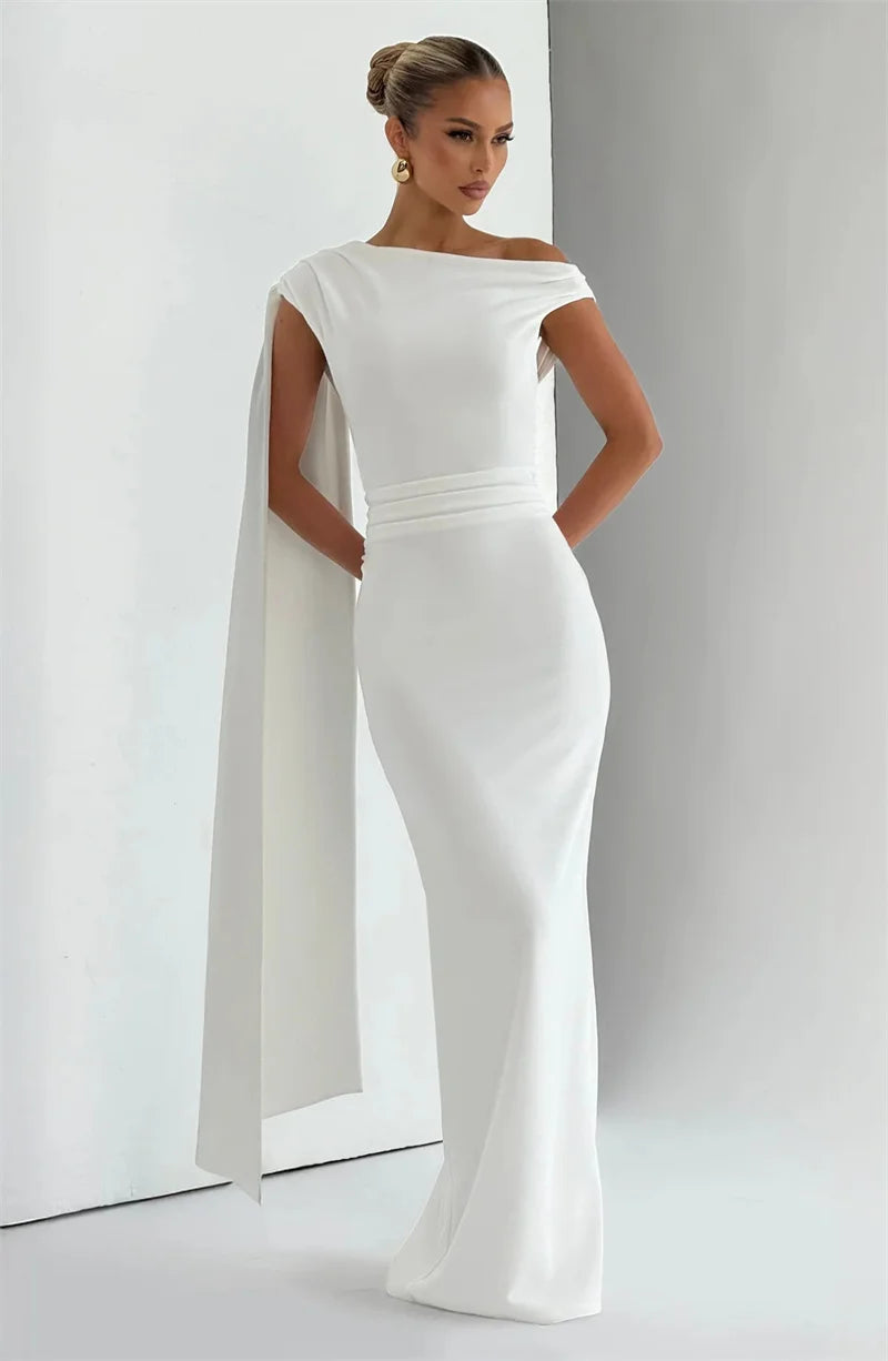 Full-length view showcasing the slim silhouette and sculptural neckline as the dress falls smoothly to the floor.