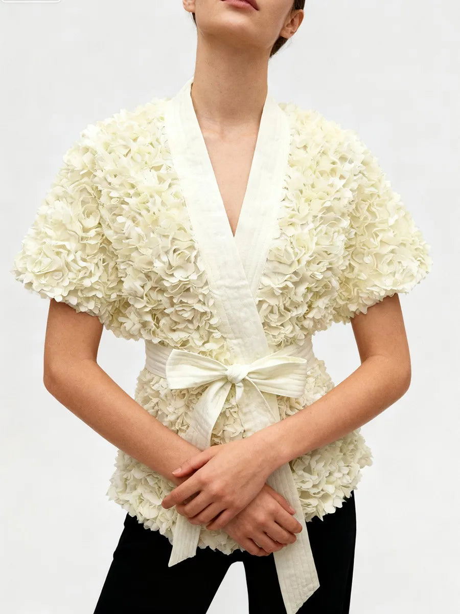 Cream V-neck tunic featuring sculptural flower detailing