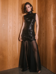 A woman modeling a shiny sequin patchwork maxi dress with a mesh turtleneck.