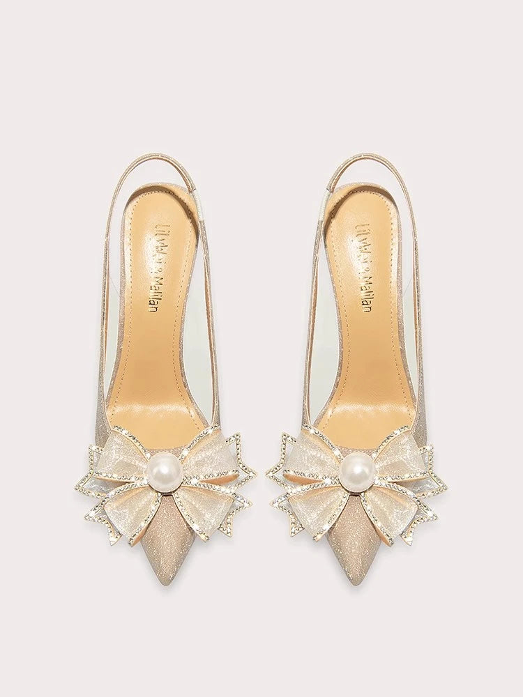 a sequin sandal with a pearl bow and a thin heel.