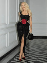 A woman wearing a sequined 3D flower gown in a chic, modern style.