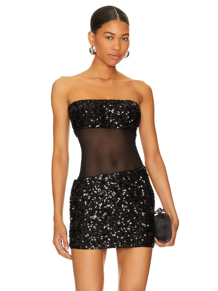 A woman wearing a sequined strapless bodycon dress in a chic, modern style.