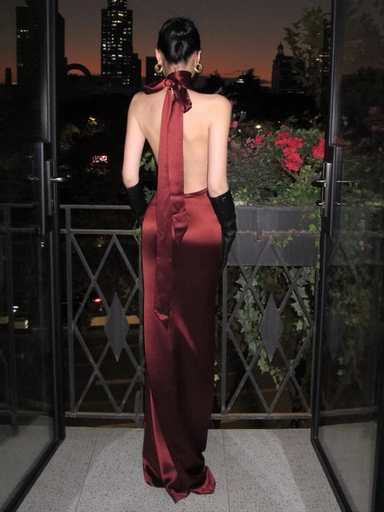 Full-length back view of a burgundy sheath gown styled for an evening event