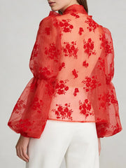 Rear view of expressive sheer blouse and lantern sleeves highlighting airy structure