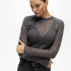 Model wearing a gray sheer crew-neck knit over a dark underlayer, showing the clean neckline and softly structured shoulder line.