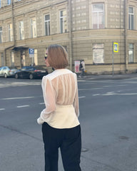 Close view of the neckline and fabric texture on a sheer-effect blouse