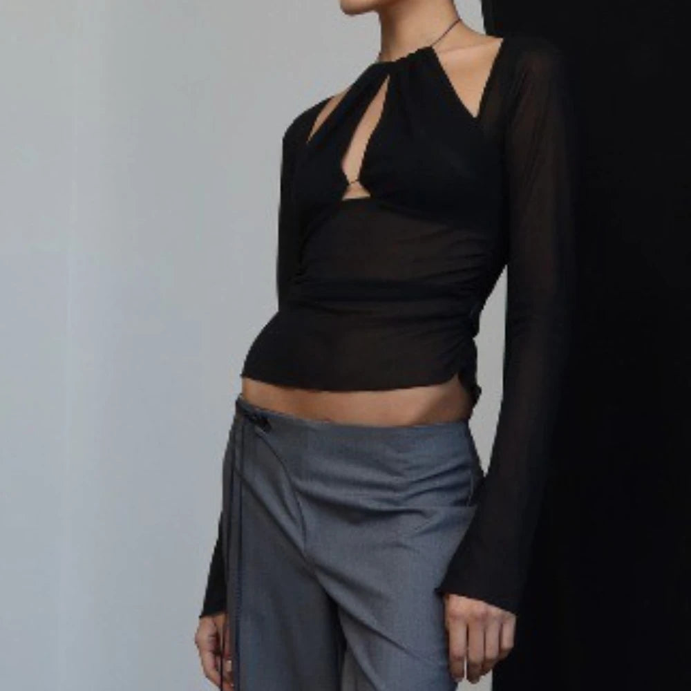 Statement sheer top styled with low-rise grey pants