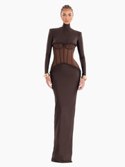 A woman modeling a sheer mesh turtleneck maxi dress with hollow-out details.