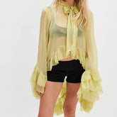 Sheer tie-neck blouse with long flared sleeves and soft ruffle hem