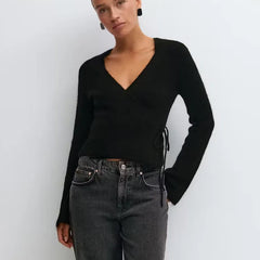 A close-up of the side tie detail on the knit sweater.