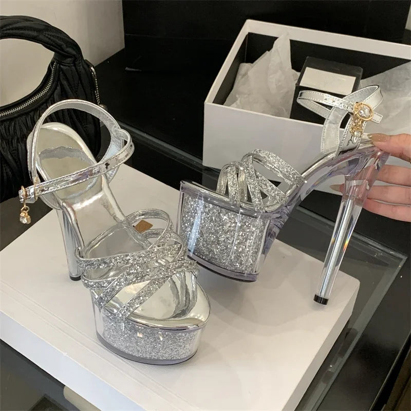 Silver glitter high-heeled shoes on a white surface with a black background