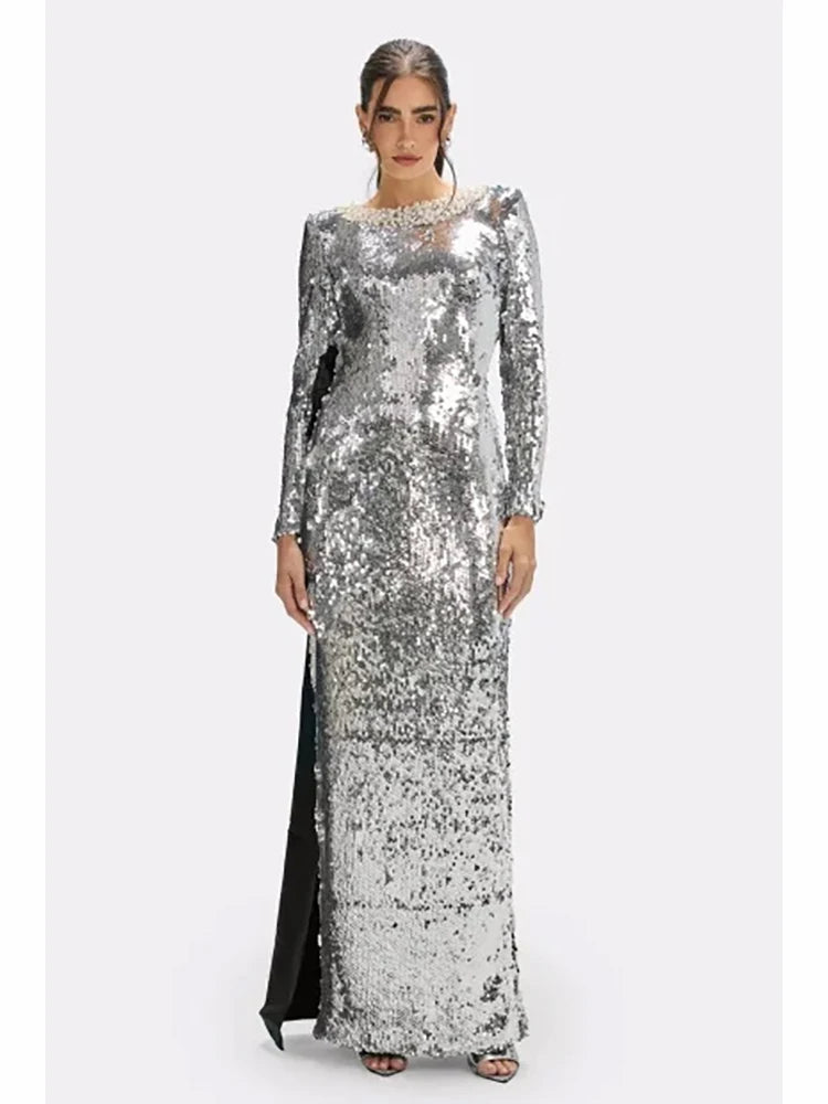 Full-length front view of a silver sequin sheath maxi dress with long sleeves and clean O-neckline on a studio background.