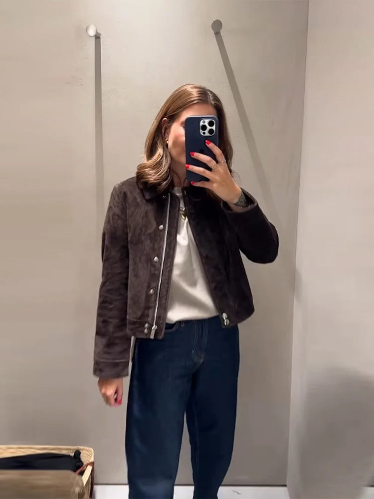 Person wearing a brown jacket, white shirt, and dark pants in a mirror selfie.