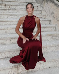 Woman in a burgundy evening gown sitting on stone steps.