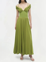 Slash neck green evening dress with slim straps and ankle-length cut worn by a model on a white background