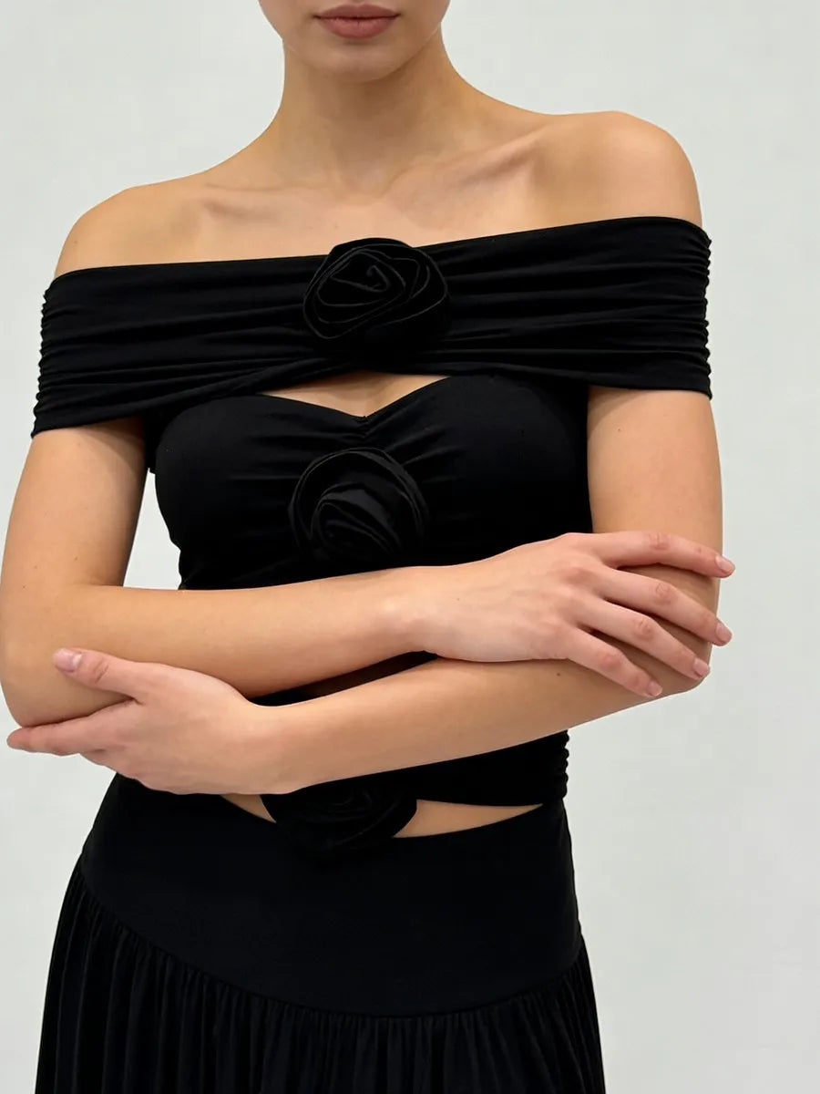Front view of a wrap-style off-shoulder top with sculpted rosette accents